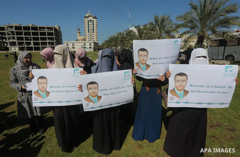 Palestinian students hold posters bearing a portrait of Palestinian journalist Mohammed al-Qiq who is imprisoned in an Israeli jail during a protest in support of his hunger strike, in Gaza city, on Feb. 24, 2016. Photo...