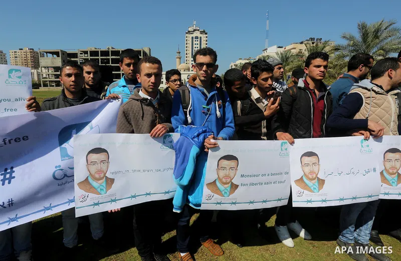 Palestinian students hold posters bearing a portrait of Palestinian journalist Mohammed al-Qiq who is imprisoned in an Israeli jail during a protest in support of his hunger strike, in Gaza city, on Feb. 24, 2016. Photo...