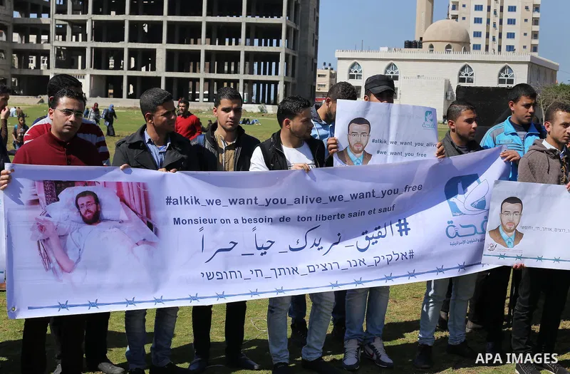 Palestinian students hold posters bearing a portrait of Palestinian journalist Mohammed al-Qiq who is imprisoned in an Israeli jail during a protest in support of his hunger strike, in Gaza city, on Feb. 24, 2016. Photo...