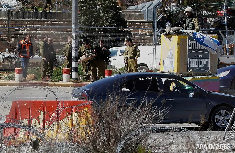 Israeli soldiers gather at the scene of an attack at the Gush Etzion junction in the West Bank, Wednesday, Feb. 24, 2016. The Israeli military says a knife-wielding Palestinian rushed toward an Israeli in the West Bank a...