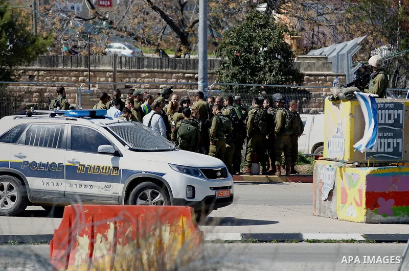 Israeli soldiers gather at the scene of an attack at the Gush Etzion junction in the West Bank, Wednesday, Feb. 24, 2016. The Israeli military says a knife-wielding Palestinian rushed toward an Israeli in the West Bank a...