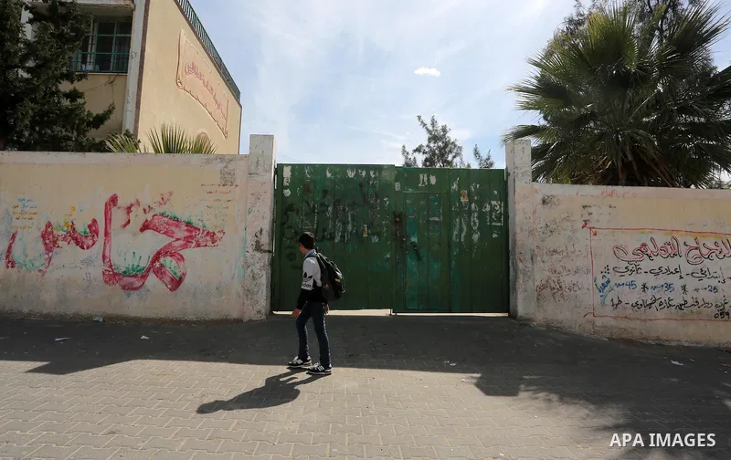 A Palestinian boy walks past a closed school during the strike of the employees of former Palestinian government in Gaza Strip and West bank to demand for pay their salaries, in Gaza city on February 25, 2016. Photo by M...