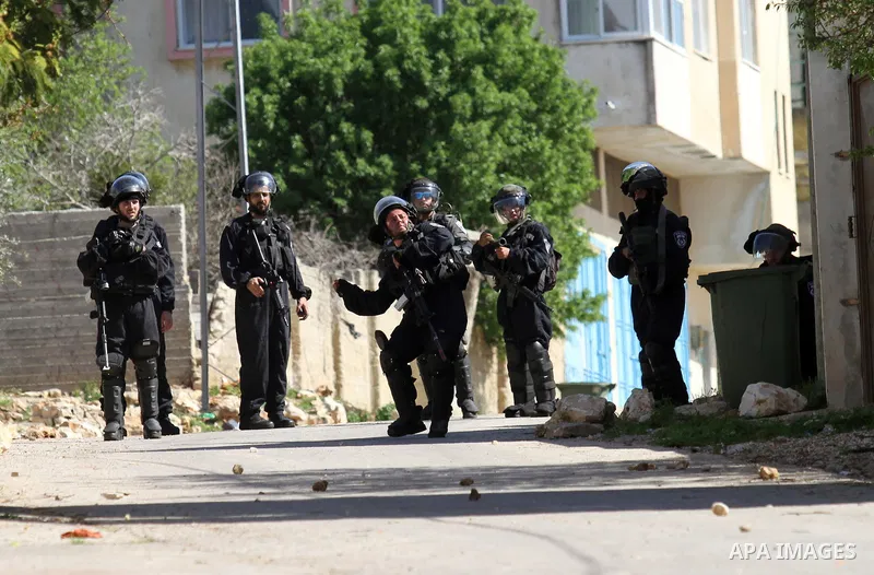Israeli security forces take position during clashes with Palestinian protesters following a protest against the expropriation of Palestinian land by Israel in the West Bank village of Kafr Qaddum, near the northern city...