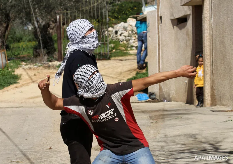 Palestinian protesters hurl stones toward Israeli security forces during clashes following a protest against the expropriation of Palestinian land by Israel in the West Bank village of Kafr Qaddum, near the northern city...