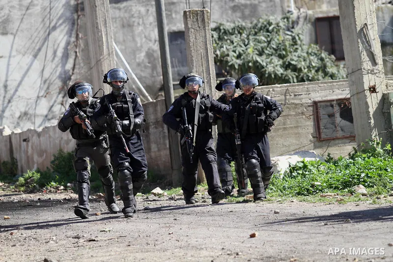Israeli security forces take position during clashes with Palestinian protesters following a protest against the expropriation of Palestinian land by Israel in the West Bank village of Kafr Qaddum, near the northern city...