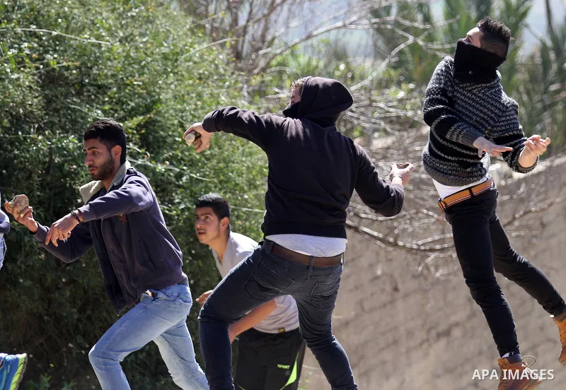 Palestinian protesters hurl stones toward Israeli security forces during clashes following a protest against the expropriation of Palestinian land by Israel in the West Bank village of Kafr Qaddum, near the northern city...
