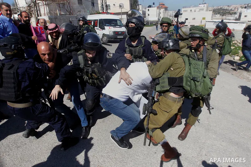Israeli soldiers and border police detain a Palestinian protester during a demonstration against the closure of Shuhada street to Palestinians, on the 22nd anniversary of the closure, in the West Bank city of Hebron Febr...