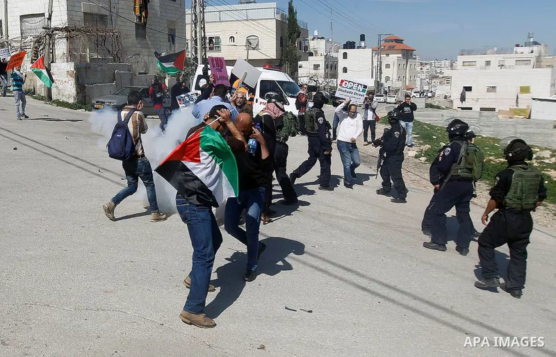 Palestinian protesters hold banners during a demonstration against the closure of Shuhada street to Palestinians, on the 22nd anniversary of the closure, in the West Bank city of Hebron February 26, 2016. Photo by Wisam...