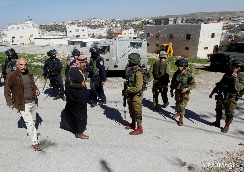 A Palestinian man scuffles with an Israeli border police during a demonstration against the closure of Shuhada street to Palestinians, on the 22nd anniversary of the closure, in the West Bank city of Hebron February 26,...