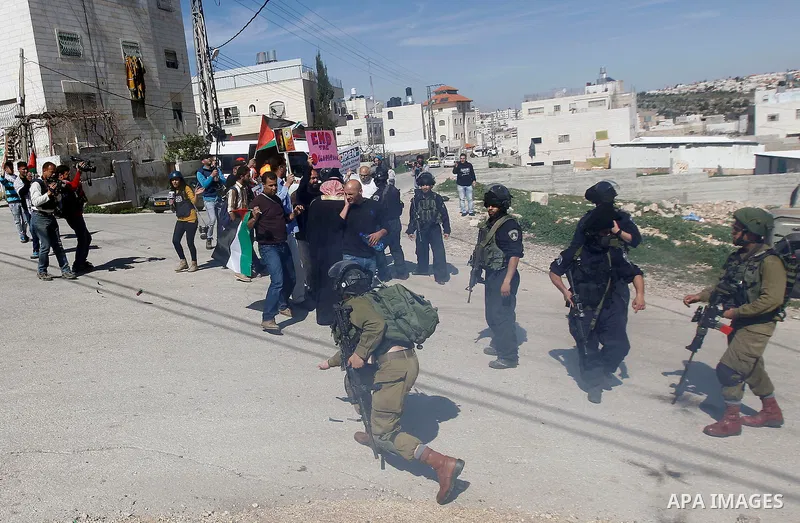 Palestinian protesters hold banners during a demonstration against the closure of Shuhada street to Palestinians, on the 22nd anniversary of the closure, in the West Bank city of Hebron February 26, 2016. Photo by Wisam...