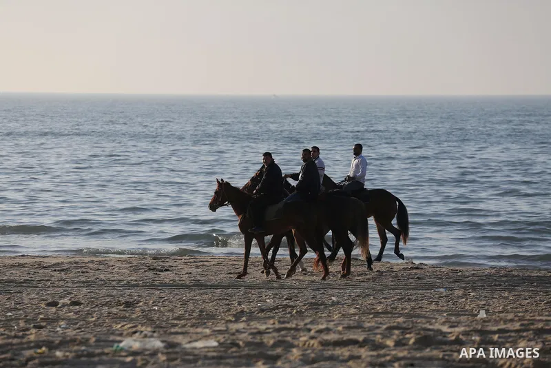 Palestinians enjoy their time at the beach of Gaza city during sunset on Feb. 26, 2016. Photo by Mohammed Asad