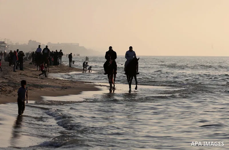 Palestinians enjoy their time at the beach of Gaza city during sunset on Feb. 26, 2016. Photo by Mohammed Asad