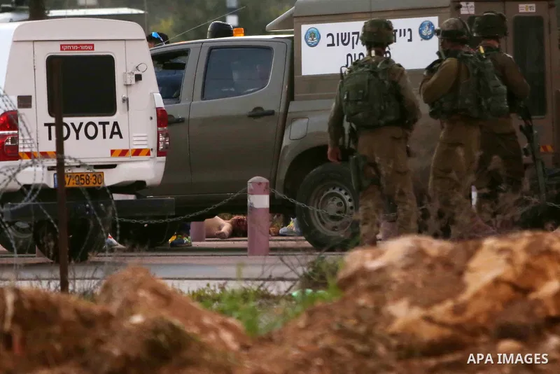 Israeli security forces gather around the body of a Palestinian man who tried to stab Israeli soldiers at a checkpoint near Ramallah, in the occupied West Bank, on February 26, 2016. The Israeli army "thwarted the attack...
