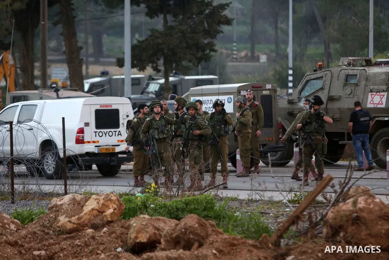 Israeli security forces gather around the body of a Palestinian man who tried to stab Israeli soldiers at a checkpoint near Ramallah, in the occupied West Bank, on February 26, 2016. The Israeli army "thwarted the attack...