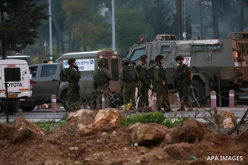 Israeli security forces gather around the body of a Palestinian man who tried to stab Israeli soldiers at a checkpoint near Ramallah, in the occupied West Bank, on February 26, 2016. The Israeli army "thwarted the attack...