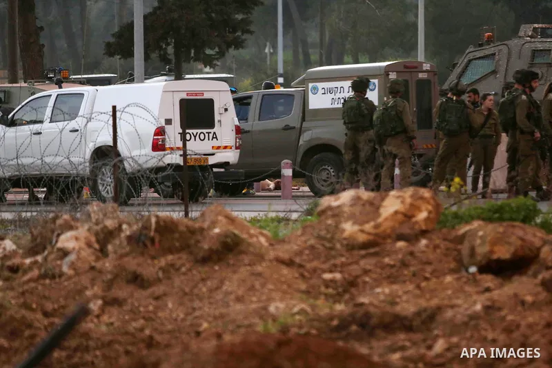 Israeli security forces gather around the body of a Palestinian man who tried to stab Israeli soldiers at a checkpoint near Ramallah, in the occupied West Bank, on February 26, 2016. The Israeli army "thwarted the attack...