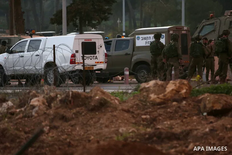 Israeli security forces gather around the body of a Palestinian man who tried to stab Israeli soldiers at a checkpoint near Ramallah, in the occupied West Bank, on February 26, 2016. The Israeli army "thwarted the attack...
