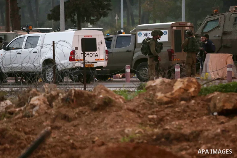 Israeli security forces gather around the body of a Palestinian man who tried to stab Israeli soldiers at a checkpoint near Ramallah, in the occupied West Bank, on February 26, 2016. The Israeli army "thwarted the attack...