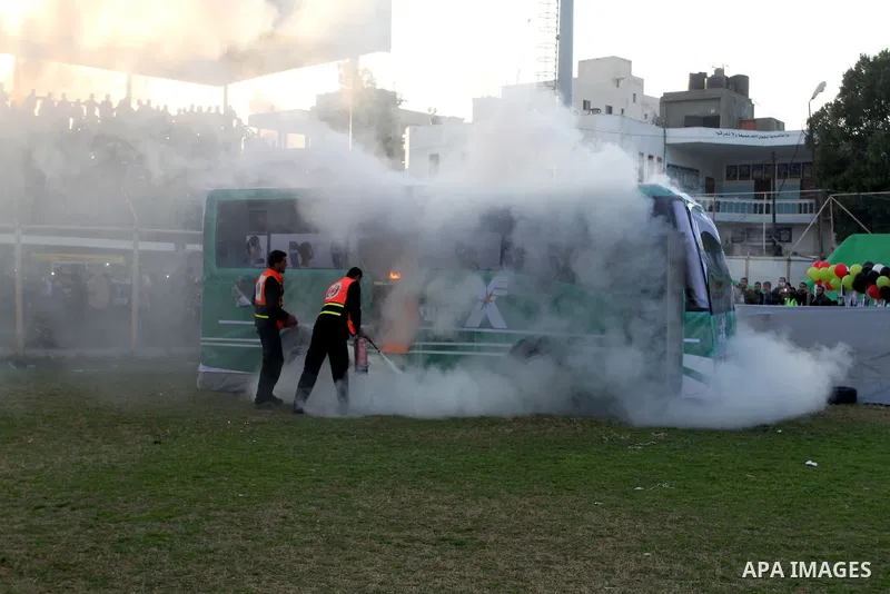 Palestinians extinguish a fire from a mock Israeli bus during a show as part of an anti-Israel rally on February 26, 2016, in the southern Gaza Strip town of Rafah. Photo by Abed Rahim Khatib