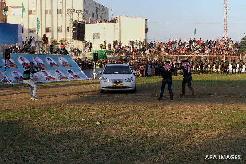Palestinian boys simulate an attack on a car during a show as part of an anti-Israel rally on February 26, 2016, in the southern Gaza Strip town of Rafah. Photo by Abed Rahim Khatib