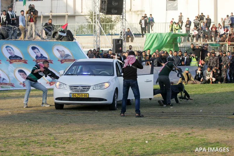 Palestinian boys simulate an attack on a car during a show as part of an anti-Israel rally on February 26, 2016, in the southern Gaza Strip town of Rafah. Photo by Abed Rahim Khatib