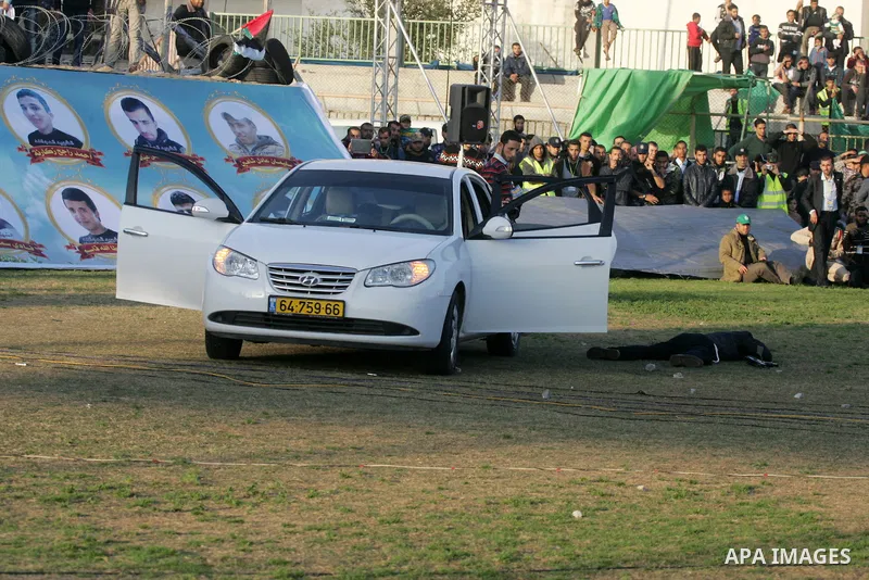 Palestinian boys simulate an attack on a car during a show as part of an anti-Israel rally on February 26, 2016, in the southern Gaza Strip town of Rafah. Photo by Abed Rahim Khatib