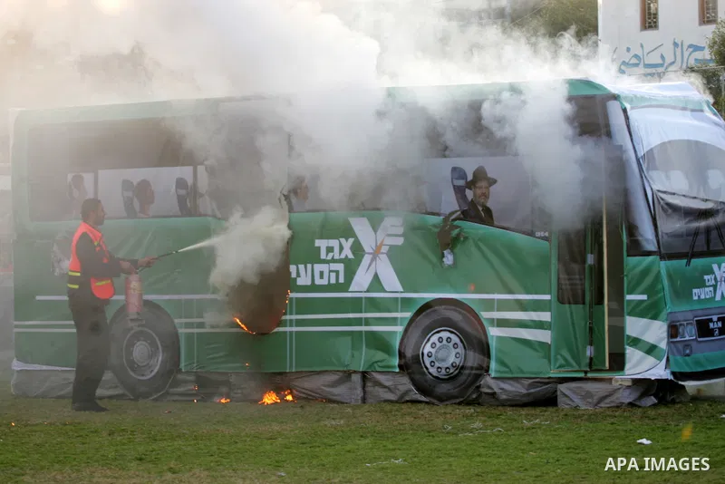 Palestinians extinguish a fire from a mock Israeli bus during a show as part of an anti-Israel rally on February 26, 2016, in the southern Gaza Strip town of Rafah. Photo by Abed Rahim Khatib