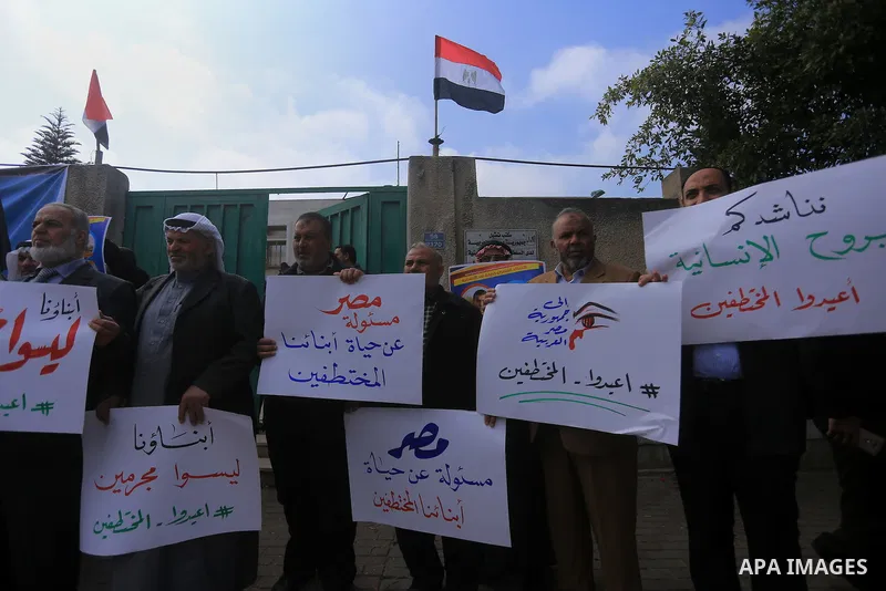 Relatives of four Palestinian men abducted by unidentified masked gunmen on August 19, hold their relatives' pictures during a protest demanding for their return, in front of the Egyptian embassy, in Gaza city, on Februa...