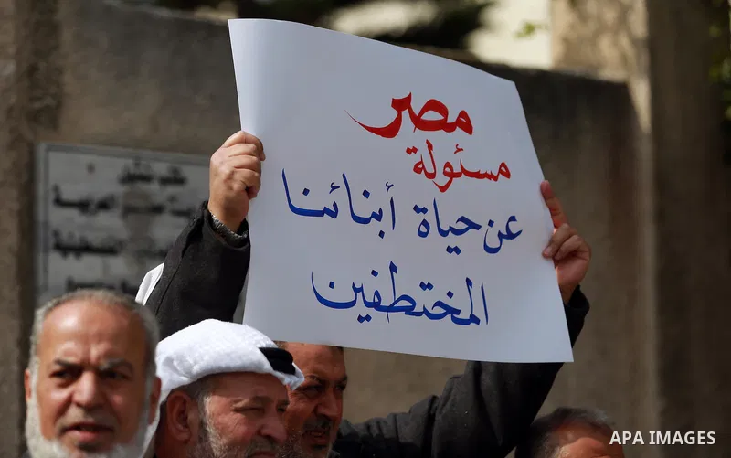Relatives of four Palestinian men abducted by unidentified masked gunmen on August 19, hold their relatives' pictures during a protest demanding for their return, in front of the Egyptian embassy, in Gaza city, on Februa...