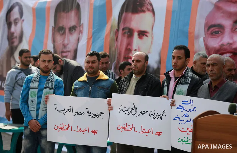 Relatives of four Palestinian men abducted by unidentified masked gunmen on August 19, hold their relatives' pictures during a protest demanding for their return, in front of the Egyptian embassy, in Gaza city, on Februa...