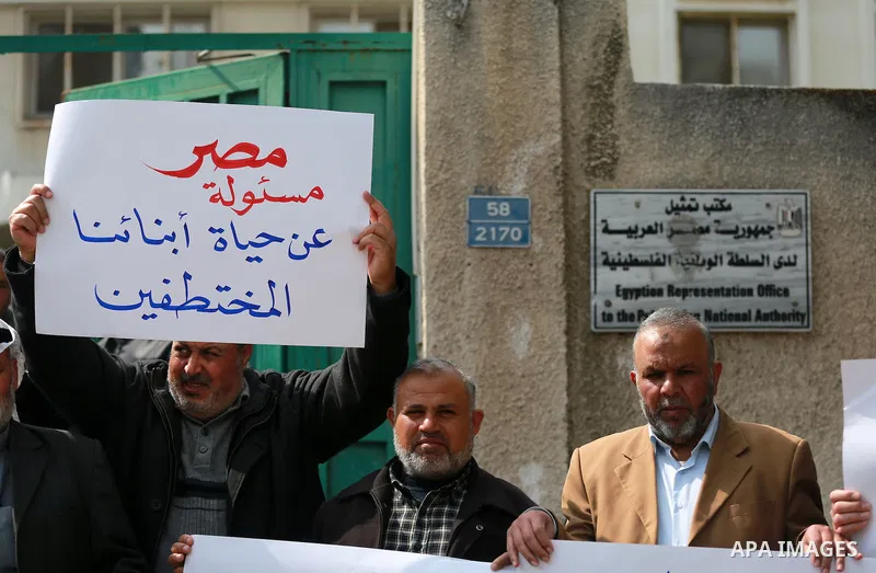 Relatives of four Palestinian men abducted by unidentified masked gunmen on August 19, hold their relatives' pictures during a protest demanding for their return, in front of the Egyptian embassy, in Gaza city, on Februa...
