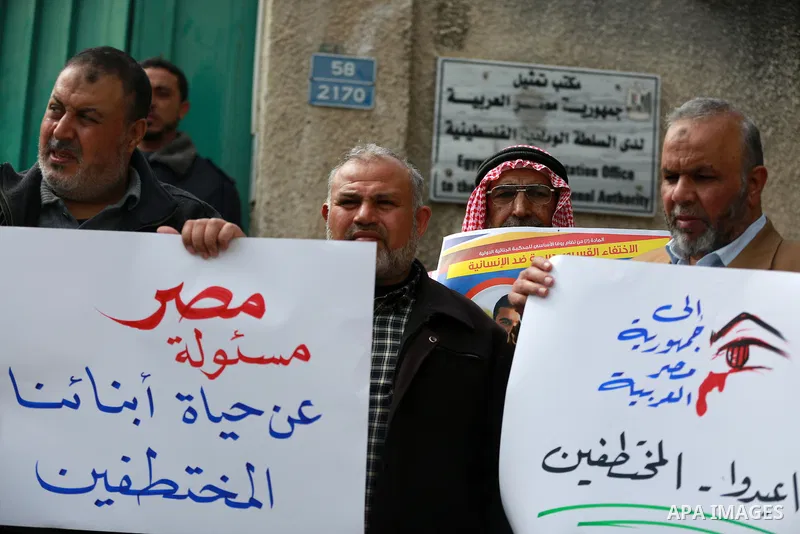 Relatives of four Palestinian men abducted by unidentified masked gunmen on August 19, hold their relatives' pictures during a protest demanding for their return, in front of the Egyptian embassy, in Gaza city, on Februa...