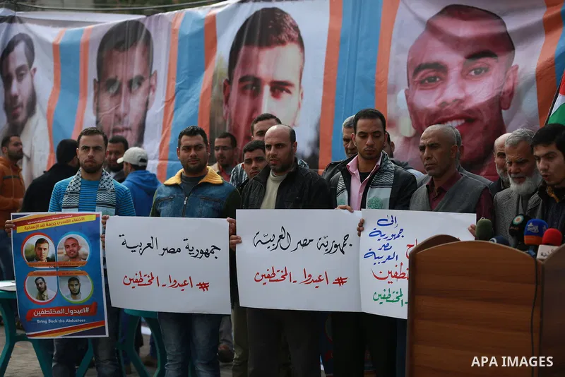 Relatives of four Palestinian men abducted by unidentified masked gunmen on August 19, hold their relatives' pictures during a protest demanding for their return, in front of the Egyptian embassy, in Gaza city, on Februa...