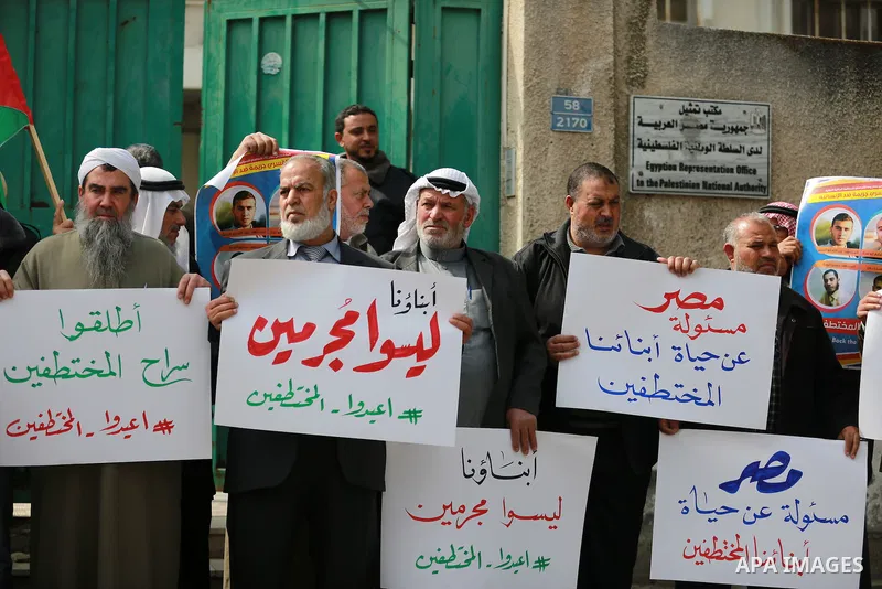 Relatives of four Palestinian men abducted by unidentified masked gunmen on August 19, hold their relatives' pictures during a protest demanding for their return, in front of the Egyptian embassy, in Gaza city, on Februa...