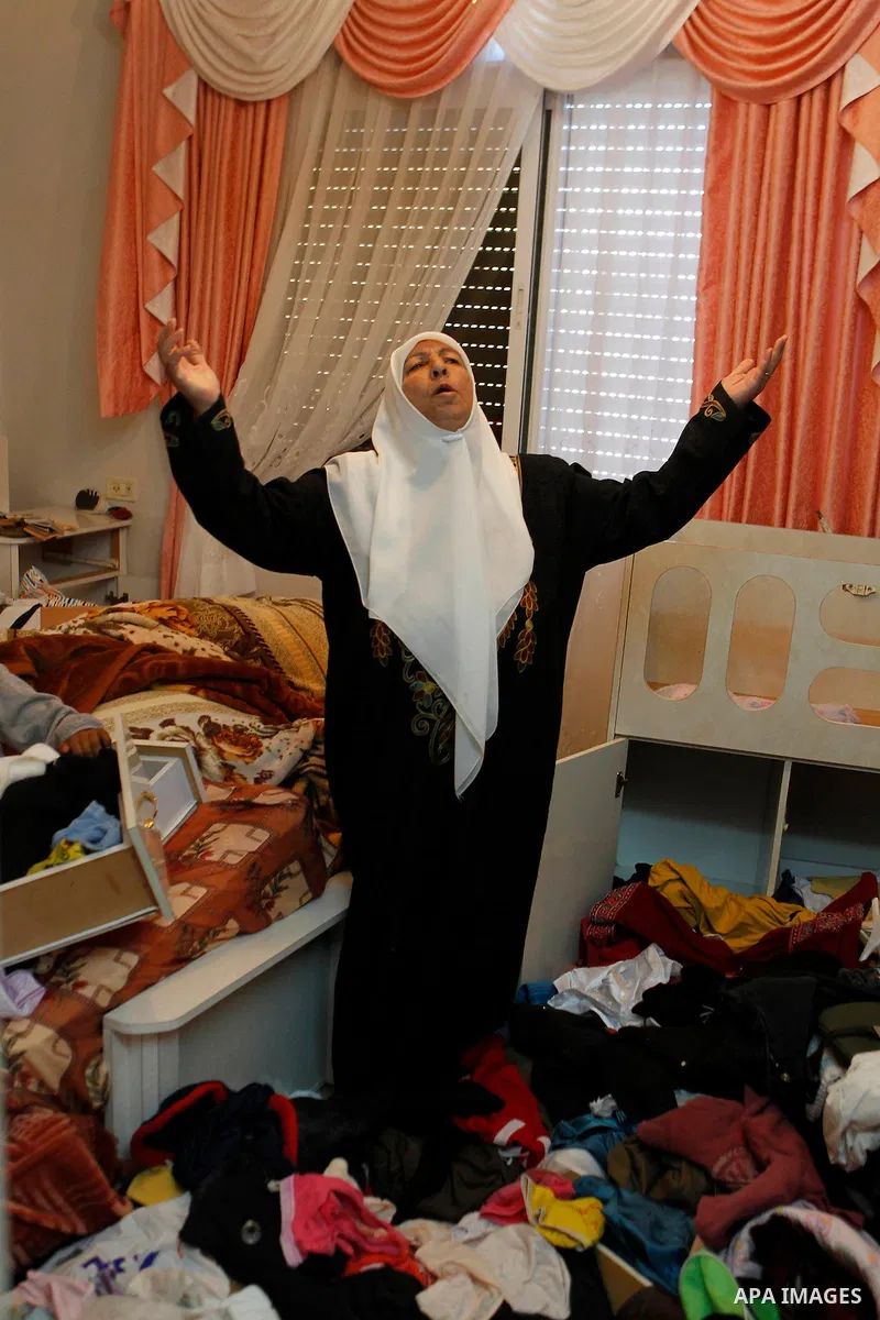 A Palestinian woman checks her belongings after a raid conducted by the Israeli army on some Palestinian houses in the West Bank city of Hebron, 29 February 2016. The Israeli army said it had arrested 16 Palestinians in...