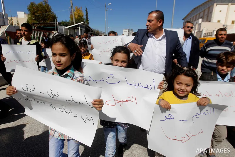 Palestinian school students take part during a protest to show solidarity with Palestinian teachers in their strike wihch entered its 16th consecutive day to call Palestinian Authority to demand their rights in the West...