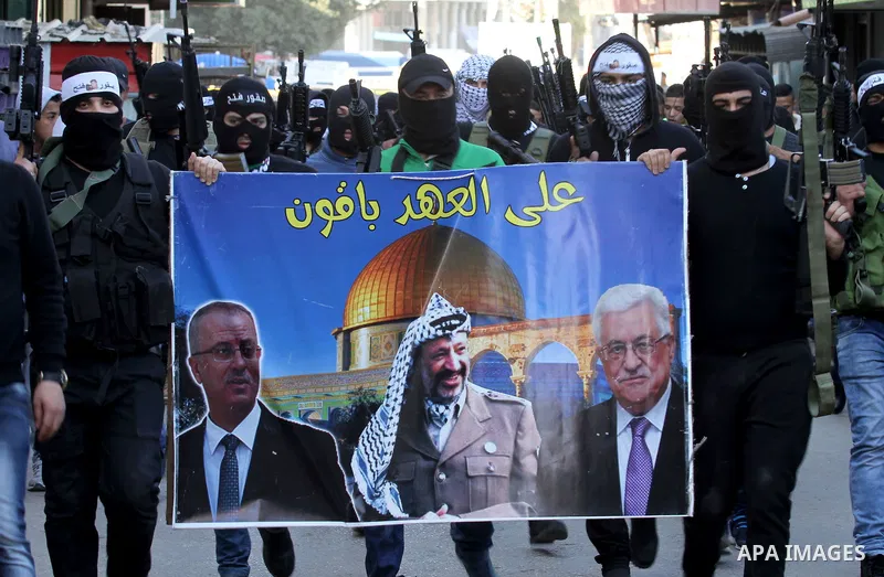 Palestinian militants of Al-Aqsa Martyrs' Brigades, a group linked to the Fatah movement take part during a protest to show solidarity with Palestinian President Mahmoud Abbas and Palestinian Prime Minister Rami Hamdalla...