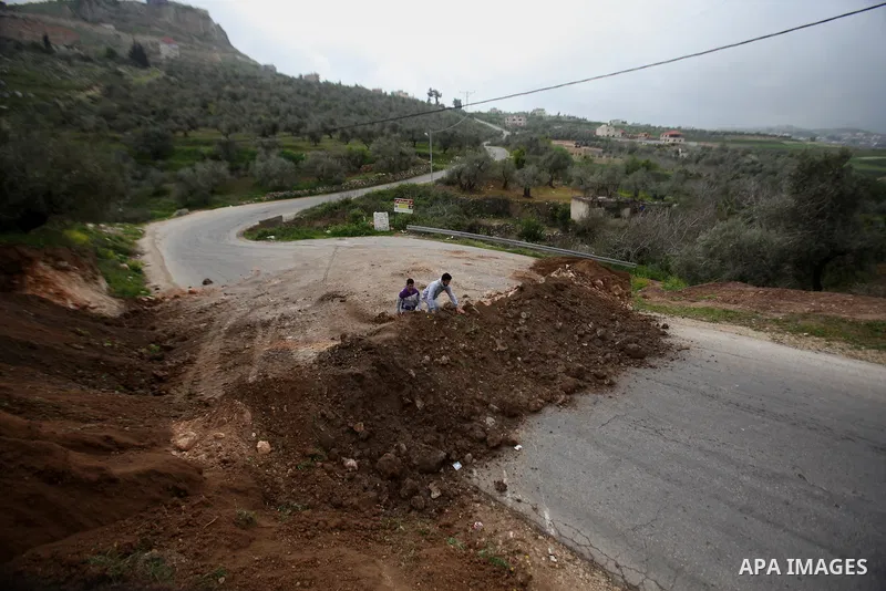 Palestinians try to access their village during the closure of the entrance to the villages of Tel and Iraq Burin near the West Bank city of Nablus, on March 3, 2016. Israeli forces closed all roads leaving Nablus city a...