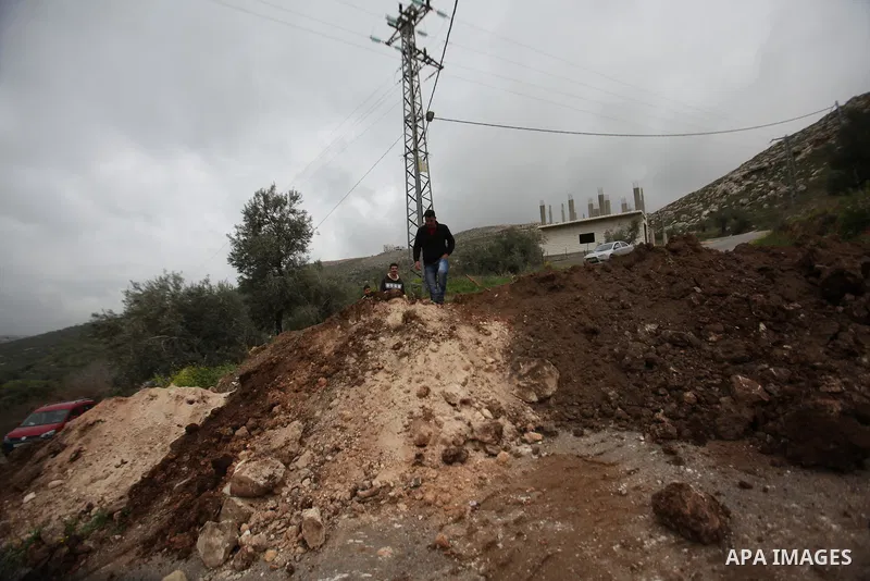 Palestinians try to access their village during the closure of the entrance to the villages of Tel and Iraq Burin near the West Bank city of Nablus, on March 3, 2016. Israeli forces closed all roads leaving Nablus city a...