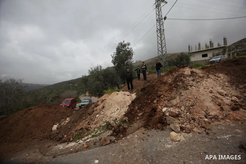 Palestinians try to access their village during the closure of the entrance to the villages of Tel and Iraq Burin near the West Bank city of Nablus, on March 3, 2016. Israeli forces closed all roads leaving Nablus city a...