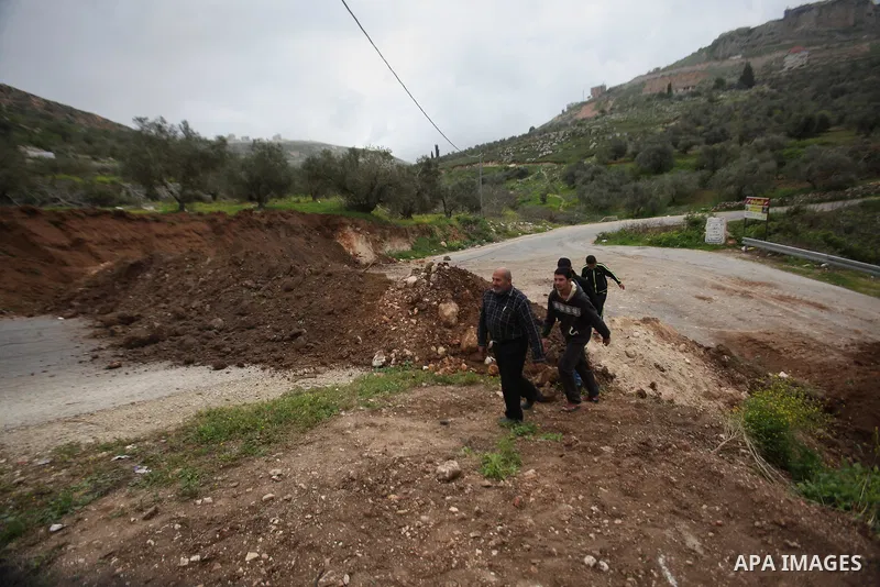 Palestinians try to access their village during the closure of the entrance to the villages of Tel and Iraq Burin near the West Bank city of Nablus, on March 3, 2016. Israeli forces closed all roads leaving Nablus city a...