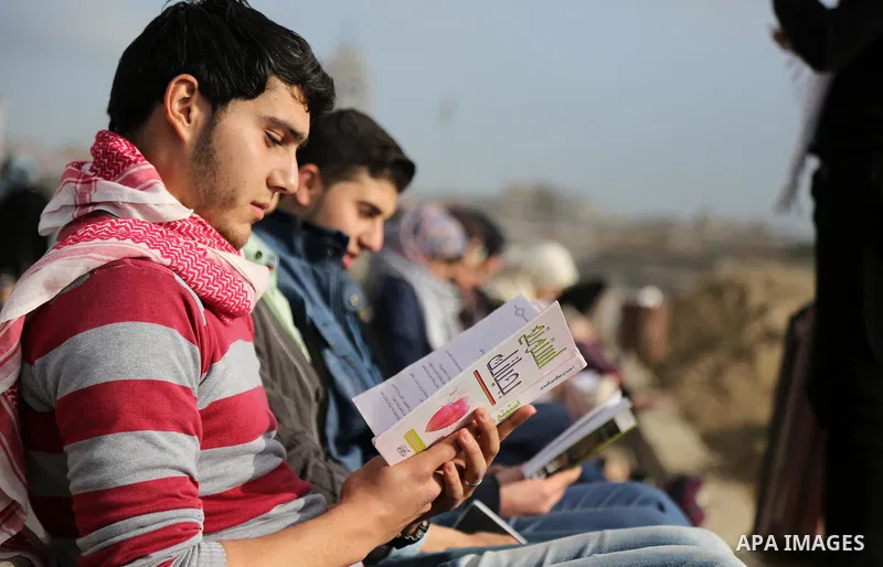 Palestinian activists participate in a reading human chain at the beach of Gaza city on March 03, 2016. Photo by Mohammed Asad