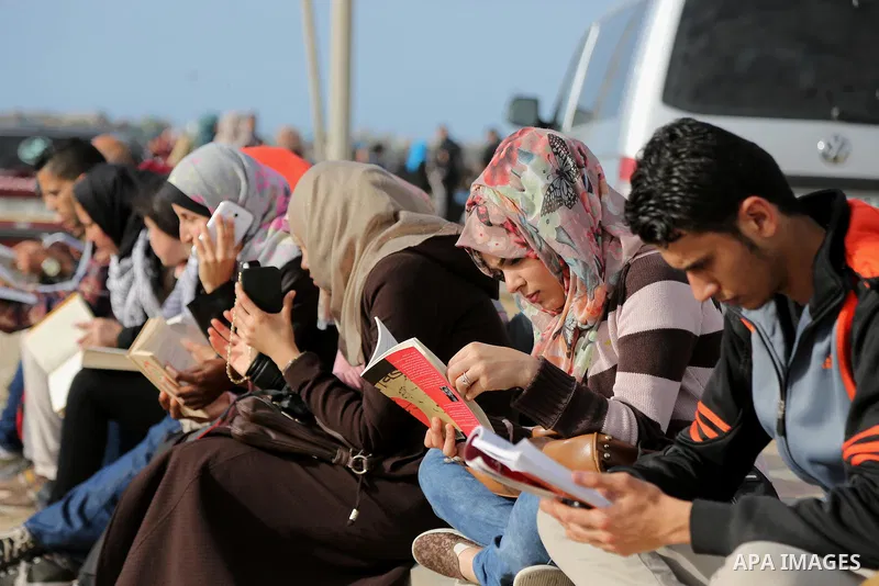 Palestinian activists participate in a reading human chain at the beach of Gaza city on March 03, 2016. Photo by Mohammed Asad