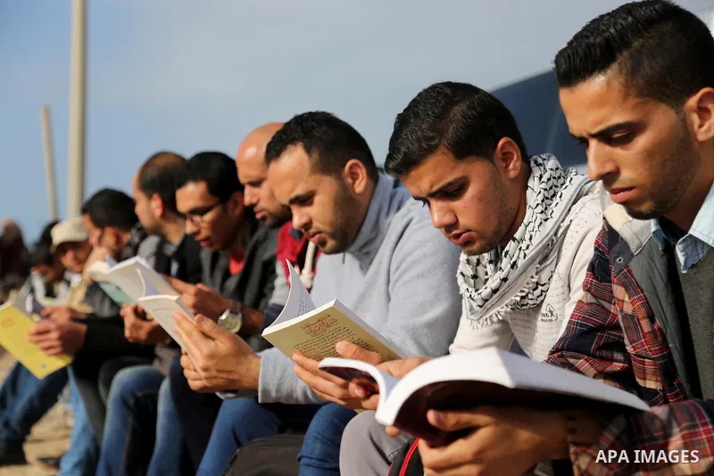 Palestinian activists participate in a reading human chain at the beach of Gaza city on March 03, 2016. Photo by Mohammed Asad