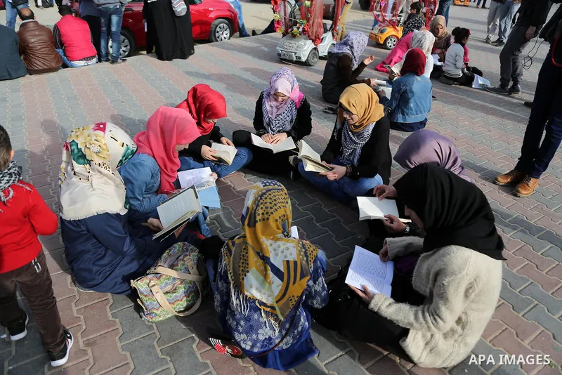 Palestinian activists participate in a reading human chain at the beach of Gaza city on March 03, 2016. Photo by Mohammed Asad