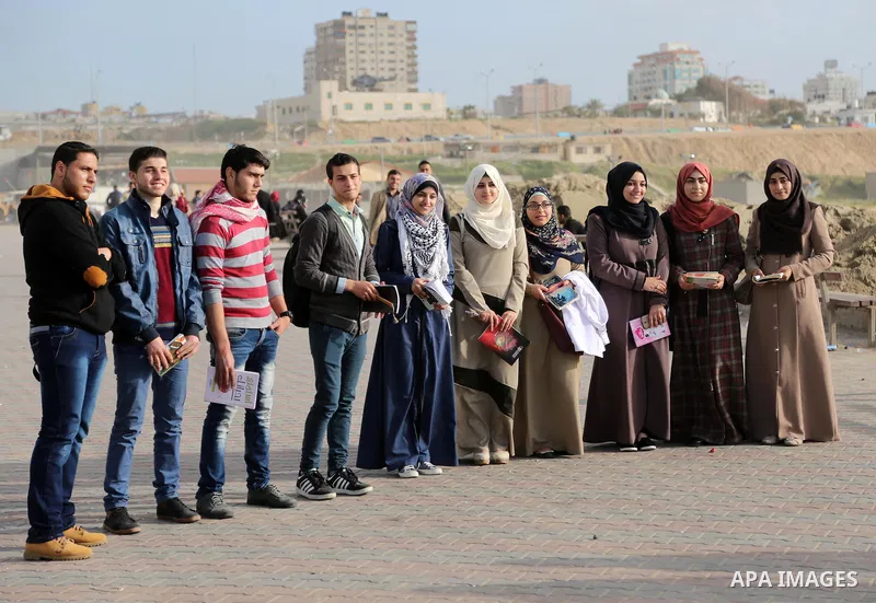 Palestinian activists participate in a reading human chain at the beach of Gaza city on March 03, 2016. Photo by Mohammed Asad