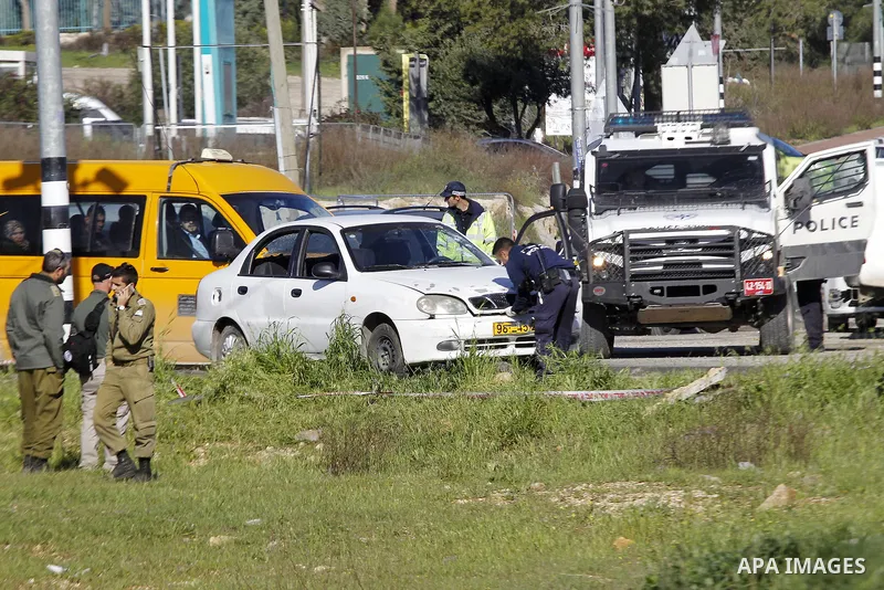 Israeli security forces inspect a car used by a Palestinian woman who, the Israeli military said, rammed it into an Israeli soldier before she was shot dead by the Israeli troops, at a main junction near the Israeli sett...