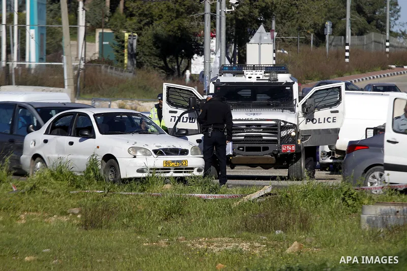 Israeli security forces inspect a car used by a Palestinian woman who, the Israeli military said, rammed it into an Israeli soldier before she was shot dead by the Israeli troops, at a main junction near the Israeli sett...