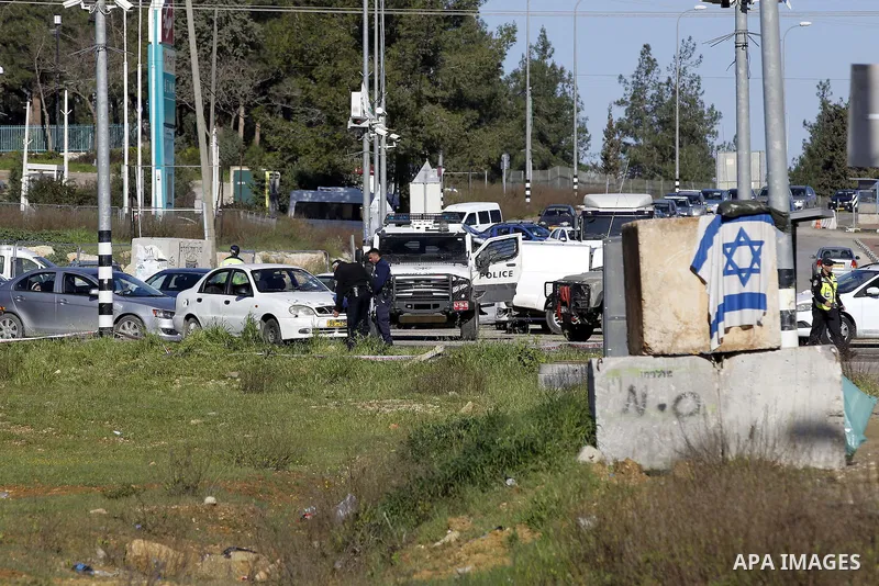 Israeli security forces inspect a car used by a Palestinian woman who, the Israeli military said, rammed it into an Israeli soldier before she was shot dead by the Israeli troops, at a main junction near the Israeli sett...