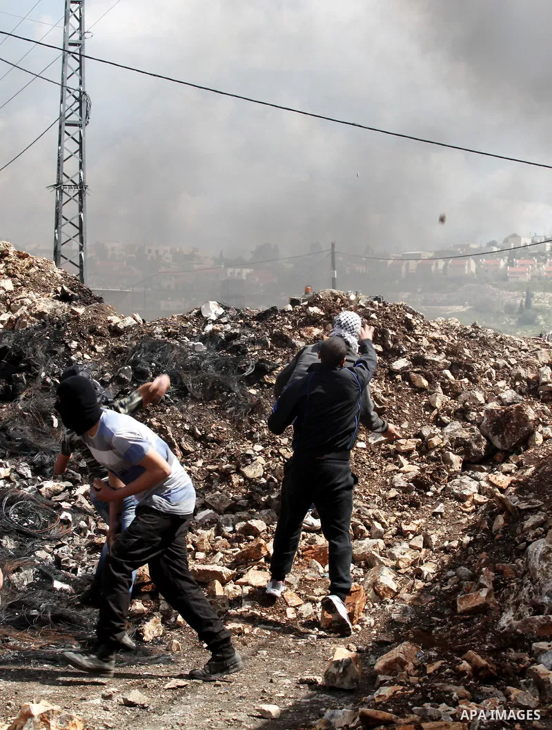 Palestinian protesters hurl stones towards Israeli security forces during clashes following a demonstration against the expropriation of Palestinian land by Israel in the village of Kfar Qaddum, near Nablus, in the occup...